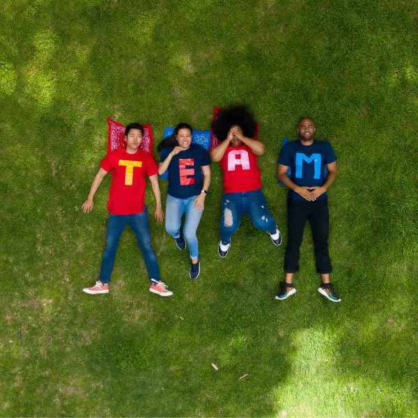 Ragazzi distesi su un prato: le loro magliette compongono la scritta TEAM
